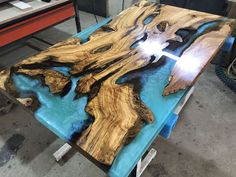 a table made out of wood with blue and black paint on the top, in a shop