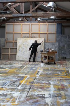 a man standing in front of a large painting