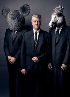 two men standing next to each other in front of a bear and horse head mask