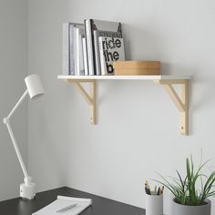 there is a desk with books on it and a lamp next to the desk top