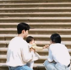 three people sitting on the bleachers and one is holding a small child in her lap