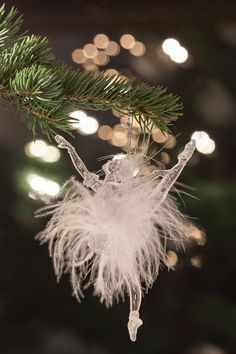 a white feather ornament hanging from a christmas tree
