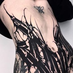 a woman's black and white tattoo on her stomach with an insect flying over it