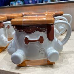 three coffee mugs with brown and white designs on them sitting next to each other