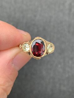 UNIQUE Early Victorian circa  approx. 1850  Center genuine Garnet approx. 9x7mm =1.25ct. Pale Yellow Genuine Old Cushion Cut 4mm Sapphires on either side approx.= .40ct. each  All securely Bezel set  open backed  Note flower detailing on sides 18x10mm face of the ring 2.9grams Low to the hand.  Notice the nice detailing on sides of the ring...some wear to this but still in good shape considering the age No Hallmarks but tests for 15k gold A bit over size 6.5 and sizable by a skilled jeweler GARN Dream Ring, Antique Rings Vintage, Pretty Crafts, Bezel Set Ring, Over Size, Jewelry Lookbook, Victorian Rings, Unique Ring, Yellow Sapphire