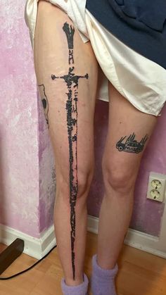 a woman's leg with a tattoo on it and a cross in the middle