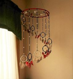 a room with a bed and a dream catcher hanging from the ceiling next to a window