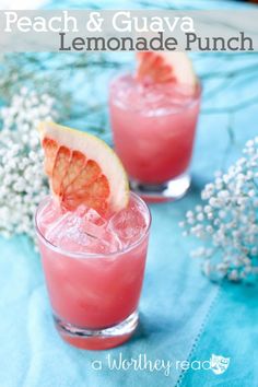 two glasses filled with pink lemonade punch sitting on top of a blue table cloth