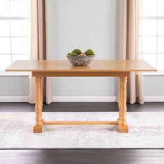 a wooden table with two green apples in a bowl on it's centerpiece