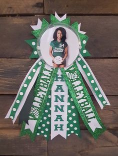 a green and white ribbon with the name hannah on it is hanging from a wooden wall