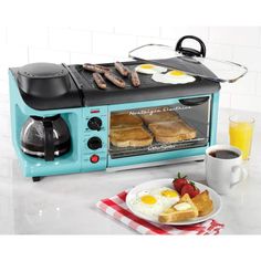 an electric toaster oven with eggs and sausages cooking in it next to a cup of coffee