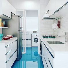 a kitchen with blue flooring and white cabinets in the center, including a washing machine