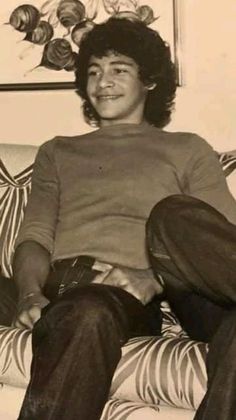 a young man sitting on top of a couch