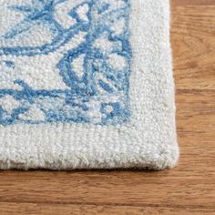 a blue and white rug is laying on a wooden floor with a wood flooring surface