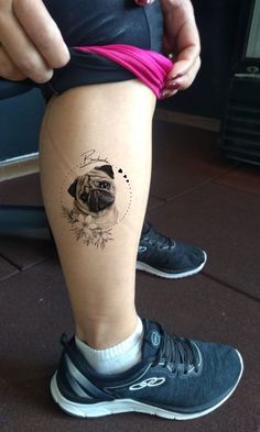 a pug tattoo on the leg of a woman's legs, with flowers around it