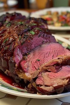 a large piece of roast beef on a plate with sauce and garnishes