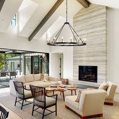 a living room filled with furniture and a fire place in the middle of an open floor plan