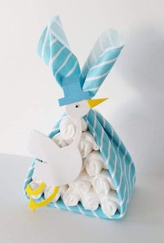 a white bird sitting on top of a blue and white towel covered in rolled up paper