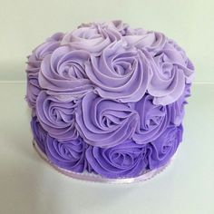 a cake with purple frosting is on a white table and it looks like roses