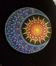 a painted plate with circles and dots on it