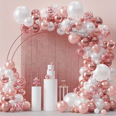 a pink and white backdrop with balloons, candles, and other items in the background