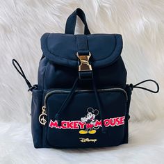 a backpack with mickey mouse on it sitting on a white furnishce background,