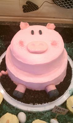 a pink pig cake sitting on top of a table