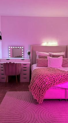 a bedroom with pink furniture and lights on the wall, along with a large bed