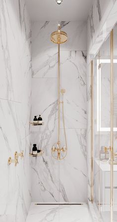 a bathroom with marble walls and flooring, gold fixtures on the shower head and shelves