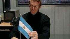 a man sitting at a table holding a flag