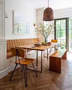 a dining room table and bench in front of a window