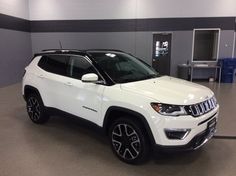 a white jeep is parked in a garage