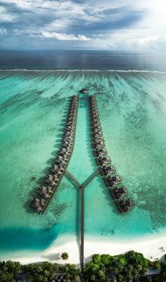 an aerial view of a resort in the middle of the ocean with water and sand