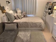 a bed room with a neatly made bed next to a night stand and dressers