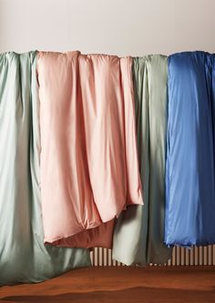 four different colored sheets hanging on a clothes line