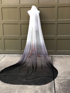 a white dress with black veil hanging from it's back