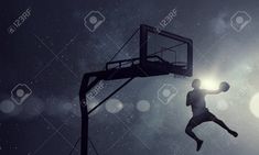 a basketball player jumping up into the air to dunk a ball at night time