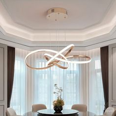 a dining room table with chairs and a chandelier hanging from it's ceiling