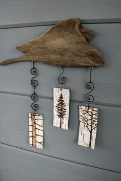 three pieces of wood are hanging on the wall next to a piece of driftwood