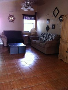 a living room filled with furniture and a lamp on top of a hard wood floor