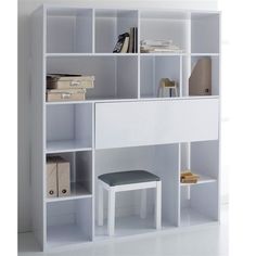 a white bookcase filled with lots of books next to a desk and chair on top of it
