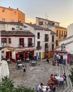 people sitting at tables in an old town square