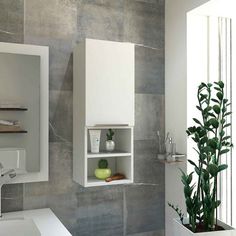 a white sink sitting under a bathroom mirror next to a green potted plant in front of it