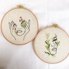 two embroidery hoops with embroidered images of women's faces and flowers on them