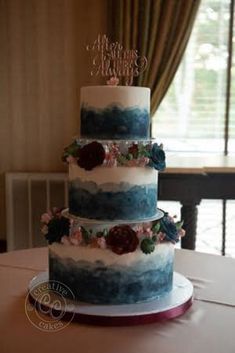 a three tiered cake sitting on top of a table in front of a window