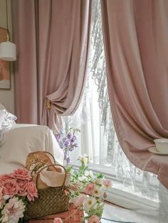 a bedroom with pink curtains and flowers on the bed