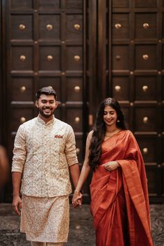 a man and woman holding hands while standing next to each other