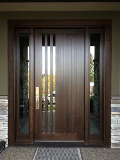 a modern wooden door with glass panels and sidelights on the front of a house