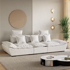 a modern living room with white couches and pillows on the floor, in front of a round mirror