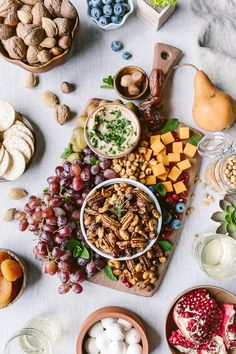 an assortment of fruits, nuts and cheeses on a table